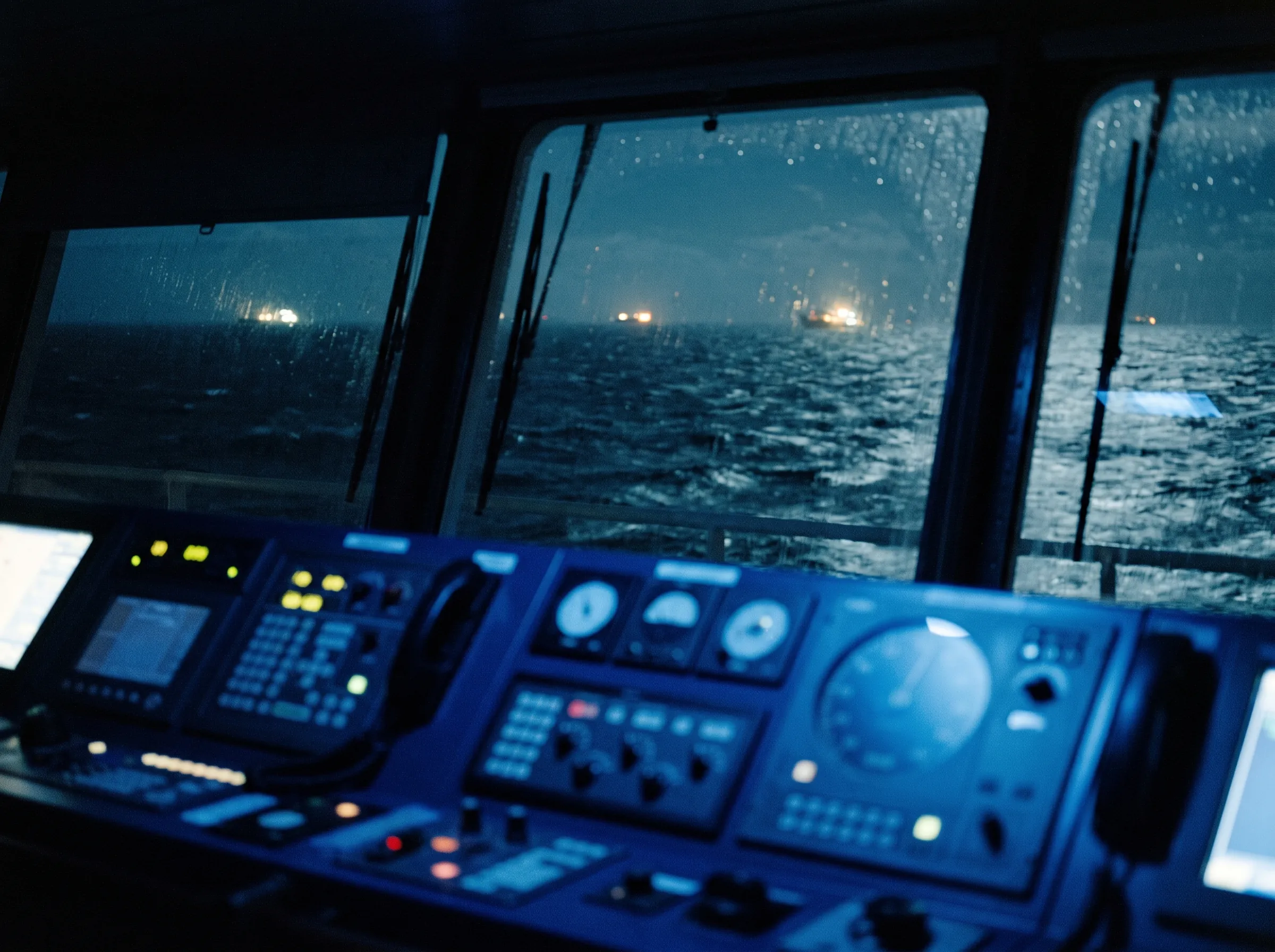 View from a ship's bridge over a dark sea at night